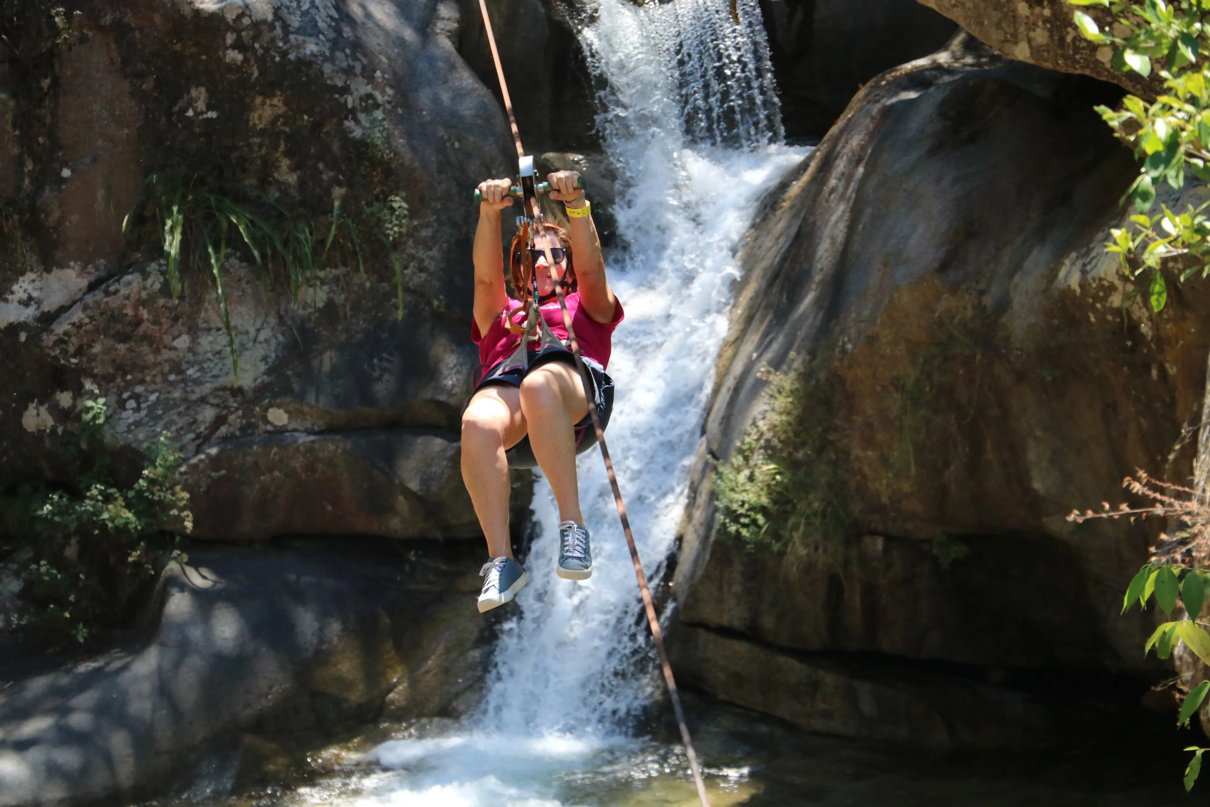 Visitante en tirolesa junto a una cascada