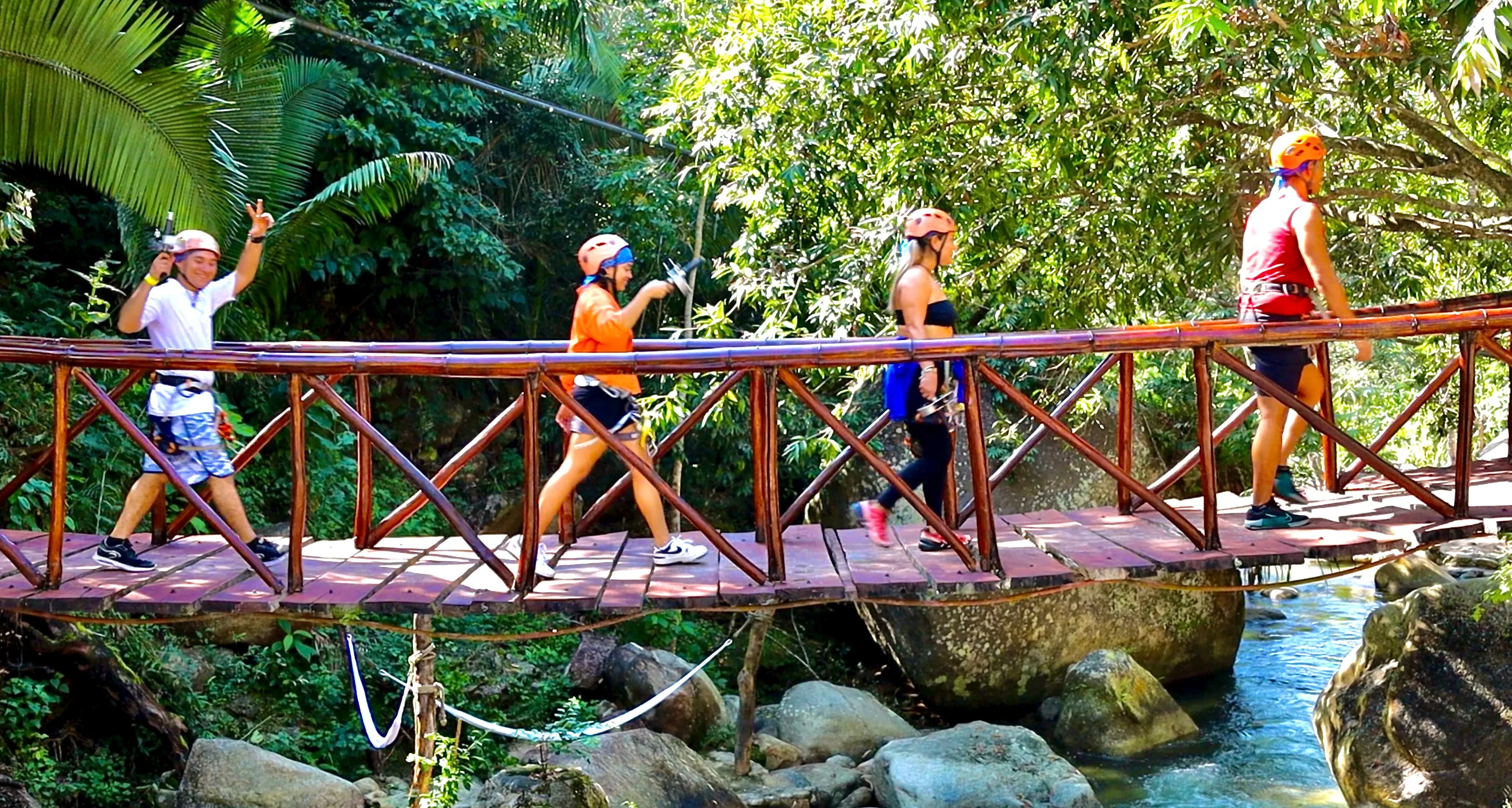 Grupo cruzando un puente de madera sobre el río